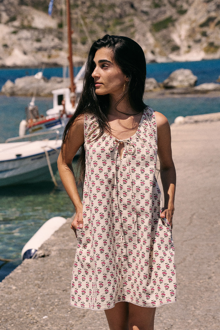 Sundress Mini Peony — full length front view at harbor with sailing boat, hand block print peony floral cotton mini dress with tie neckline, coastal lifestyle | Daughters of India